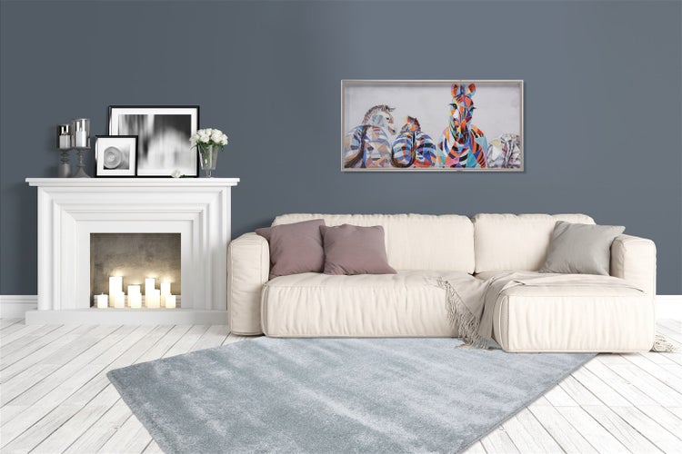 Modernes Wohnzimmer mit hellblauem Teppich, weißem Sofa, weißem Kaminumbau mit Kerzen und dunkelgrauer Wand.