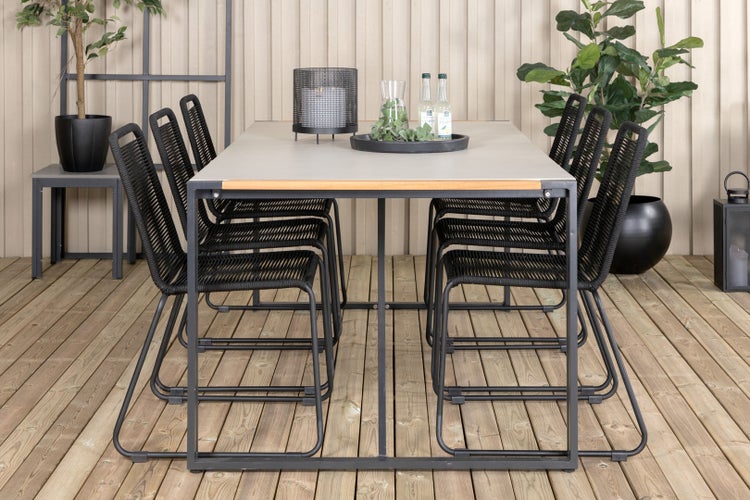 Esstisch mit sechs Stühlen für den Außenbereich auf einer Holzterrasse.