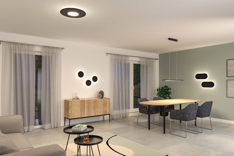 Modern eingerichtetes Wohn- und Esszimmer mit verschiedenen Decken-, Pendel- und Wandleuchten, einem Esstisch aus Holz und einem Sideboard.