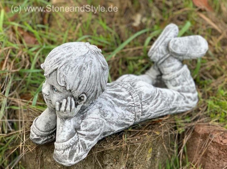 Steinfigur eines liegenden Jungen als Dekoration für den Garten aus wetterfestem Steinguss
