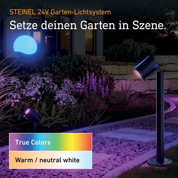 Steinel 24 Volt Garten Lichtsystem in einem nachts beleuchteten Garten mit LED Strahlern, Wegeleuchte, True Colors Funktion und warmweißem Licht.