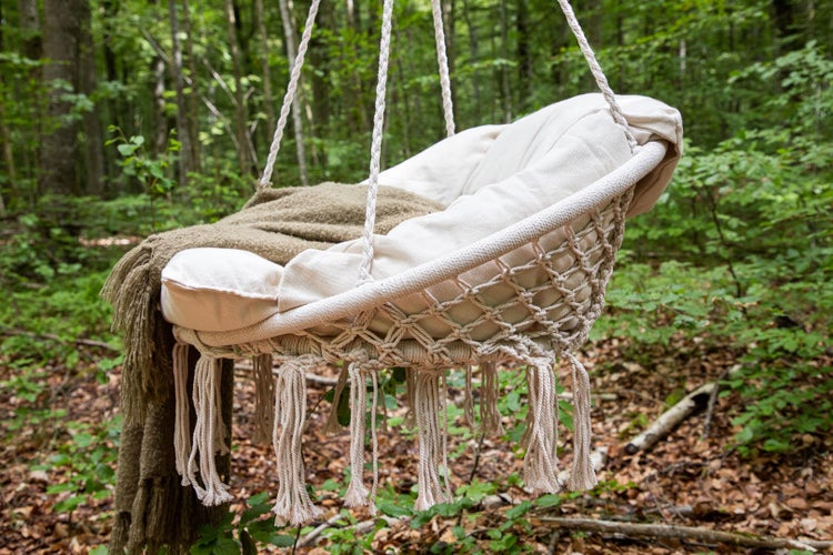 Hängesessel mit Kissen und Decke im Wald