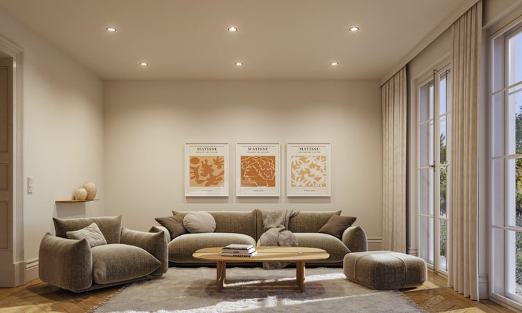 Helles, modernes Wohnzimmer mit Sofa, Sessel, Couchtisch und drei Matisse-Kunstdrucken an der Wand.