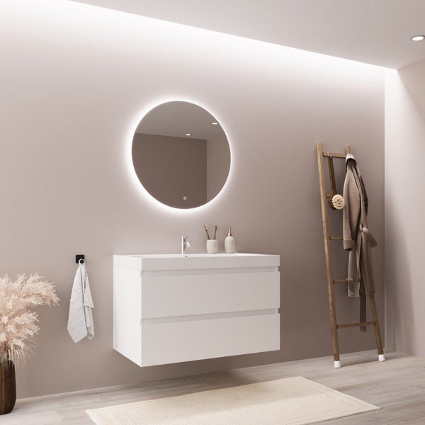 Modernes Badezimmer mit weißem Hängewaschtisch, rundem LED-Spiegel und einer Handtuchleiter aus Holz.