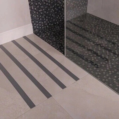 Badezimmer mit Duschkabine und Bodenfliesen mit Antirutschstreifen