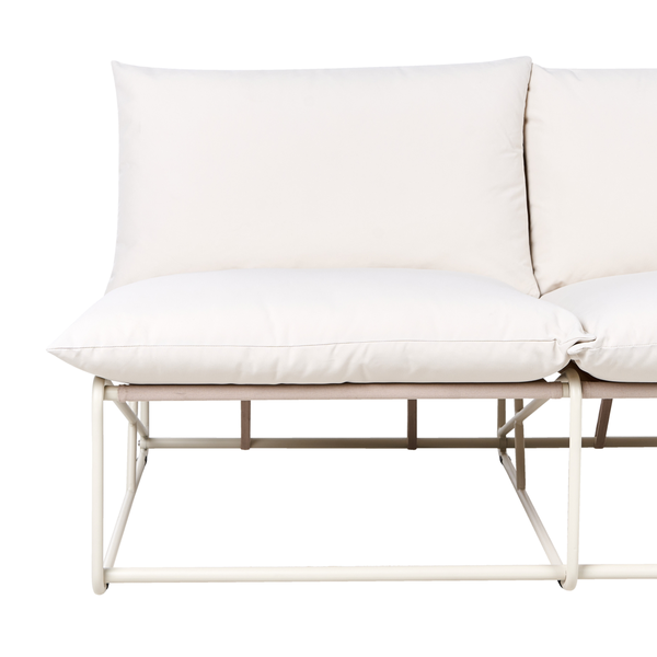 Nahaufnahme eines hellen Sofas mit Metallrahmen und weichen Kissen