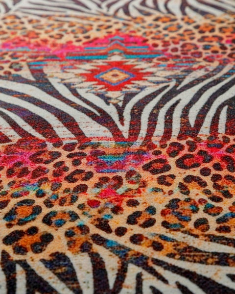 Nahaufnahme eines Teppichs mit Leopardenmuster, Zebrastreifen und geometrischem Ethno-Design.
