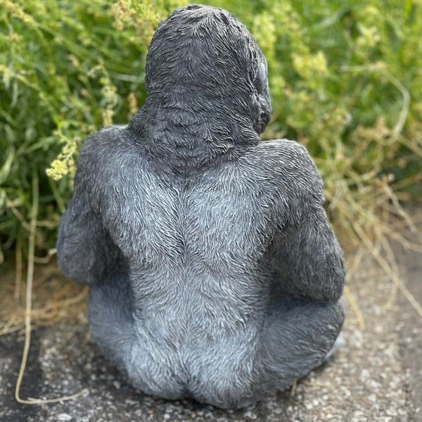 Dekorative Gartenfigur in Form eines sitzenden Gorillas aus wetterfestem Kunststein für den Außenbereich.
