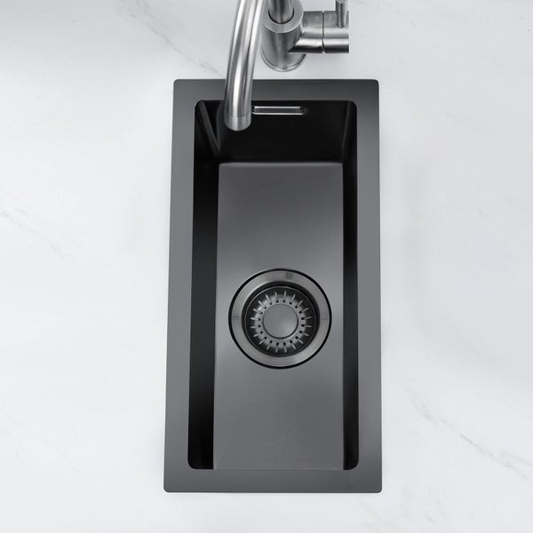 Rechteckiges Einbauspüle-Becken in schmalem Format mit Ablauf und Wasserhahn in einer Arbeitsplatte montiert.
