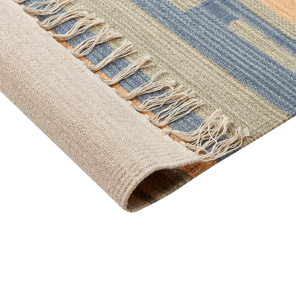 Gemusterter Teppich in einem Wohnzimmer mit Sofa und Pouf