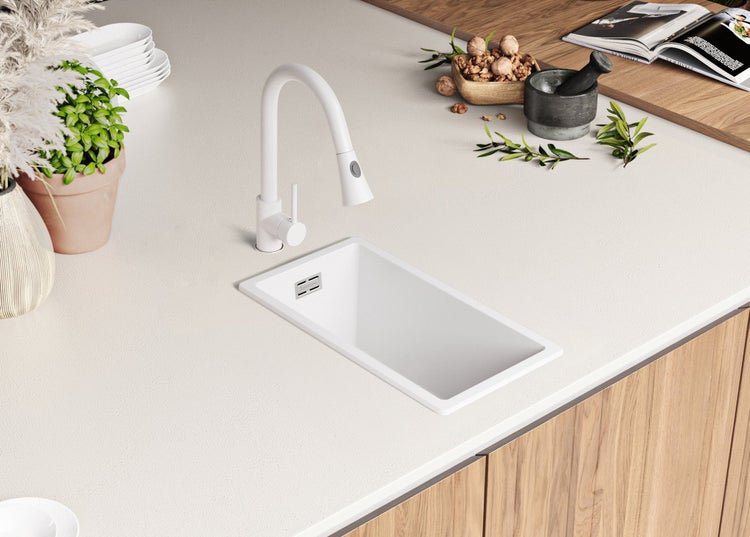 Küchenszene mit weißer Spüle und Armatur auf einer Arbeitsplatte