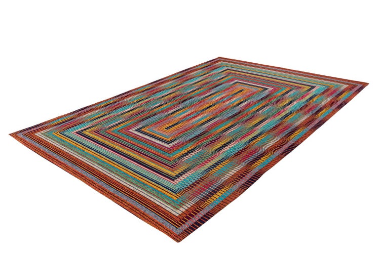 Rechteckiger Teppich mit buntem geometrischem Muster aus konzentrischen gestreiften Rechtecken.