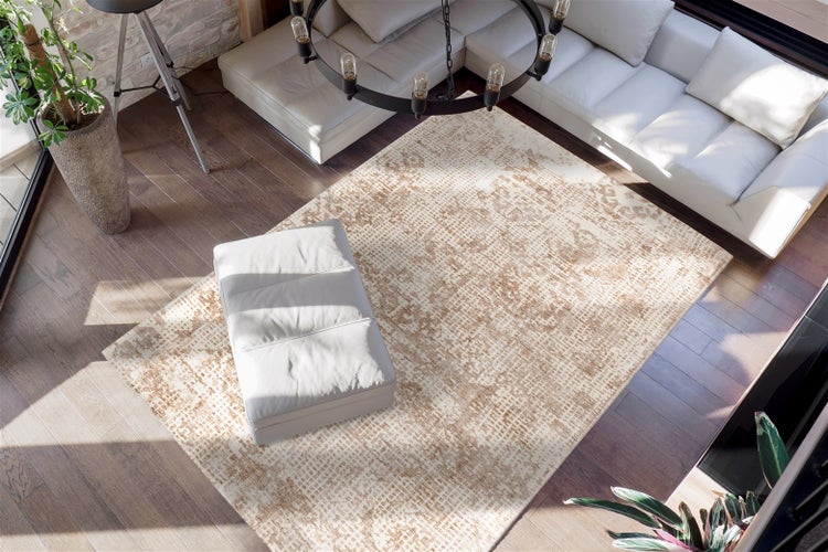 Moderner Wohnraum mit rechteckigem Teppich mit abstraktem Muster in Beige und Braun auf dunklem Holzboden, weißem Sofa und Hocker.