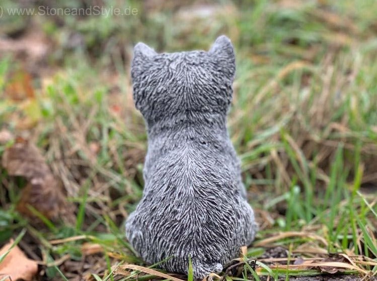 Steinfigur Katze sitzend zur Gartendekoration in einer Wiese