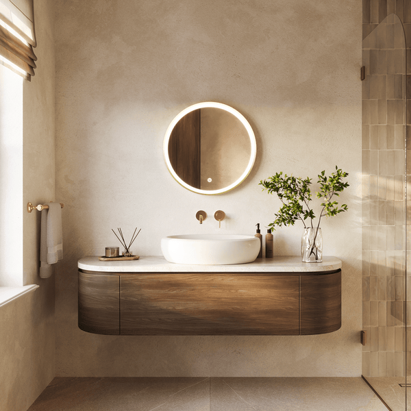 Modernes Badezimmer mit holzfarbenem Waschtisch, rundem LED Spiegel und Aufsatzwaschbecken vor einer strukturierten Wand.
