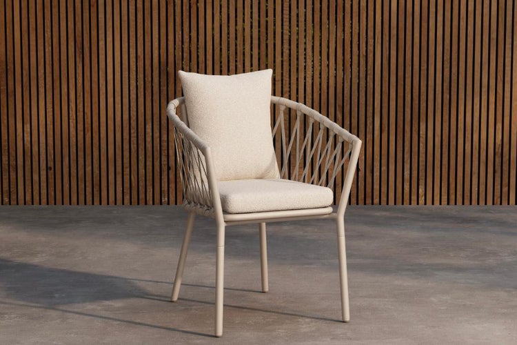 Gartenstuhl mit Kissen und Seilbespannung vor Holzwand