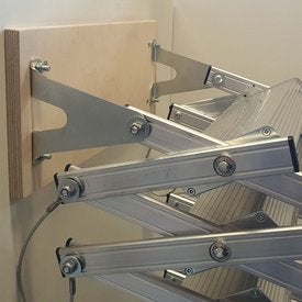 Befestigungsmechanismus einer Scherentreppe aus Aluminium an einer Holzplatte.