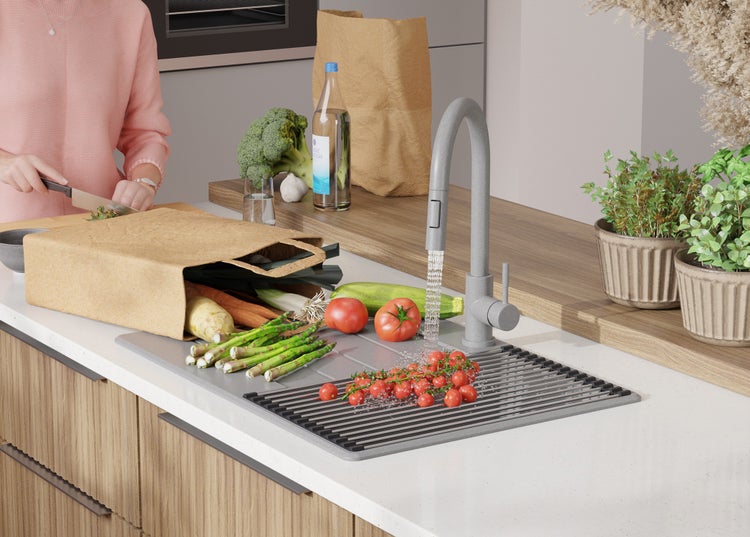 Eine Küche mit frischen Lebensmitteln, einem grauen Wasserhahn und einer Abtropfmatte für die Spüle