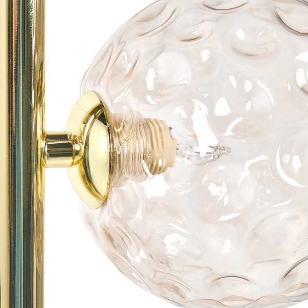 Detailaufnahme einer Lampe mit einem Lampenschirm aus Glas und einem Metallsockel