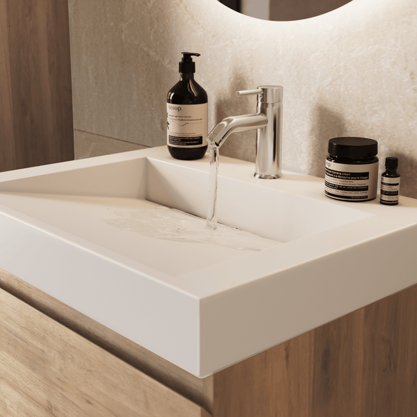 Modernes Bad mit weißem rechteckigem Waschbecken auf Holzunterschrank, verchromter Armatur mit Wasserstrahl und Bad-Accessoires.