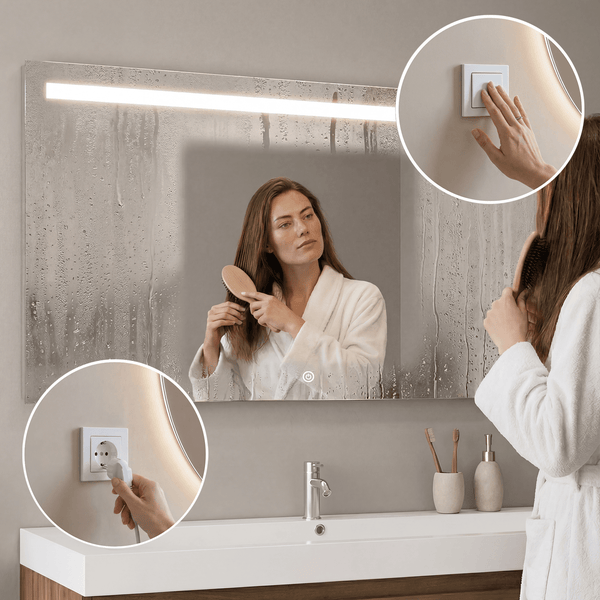 Rechteckiger Badezimmerspiegel mit LED Beleuchtung, Antifog Funktion und Touch Schalter über einem Waschbecken mit Armatur und Accessoires.
