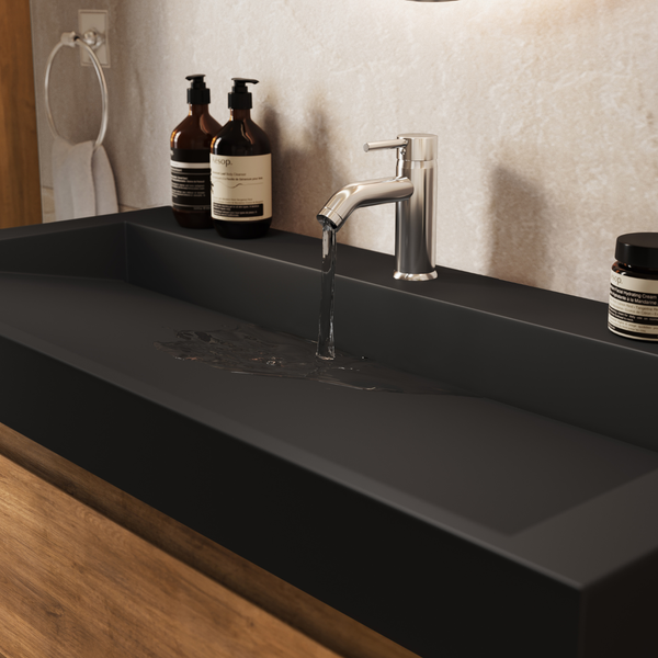 Modernes Badezimmer mit einem mattschwarzen Waschbecken und einer metallischen Einhebelarmatur aus der Wasser fließt.