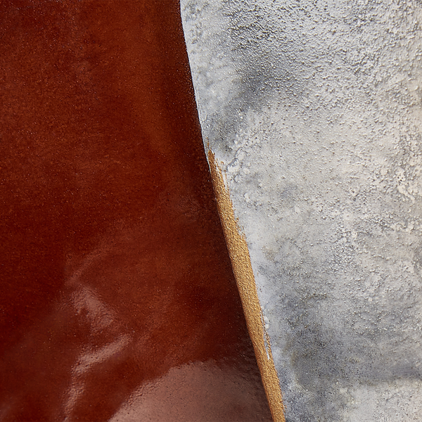 Dekorative Szene mit Spiegel, Aufbewahrungskörben, Kerze, Skulptur und Buchständer auf einem Holzschrank.