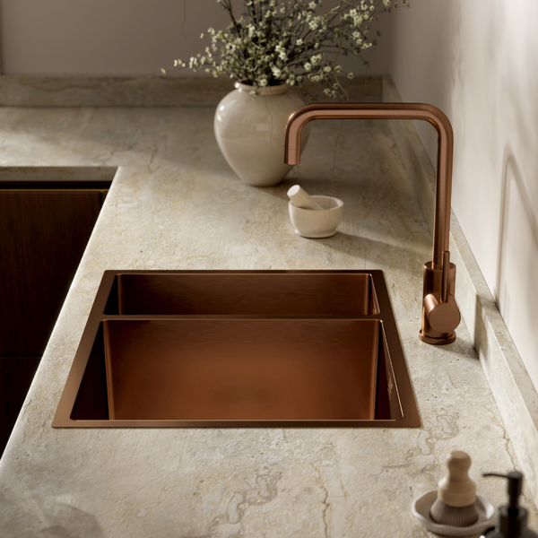 Einbauwaschbecken mit zwei Becken und passende Küchenarmatur in einer modernen Küche mit Steinplatte und dekorativen Accessoires.