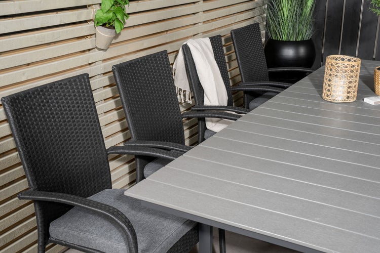 Gartenszene mit Esstisch und vier Stühlen aus Rattan