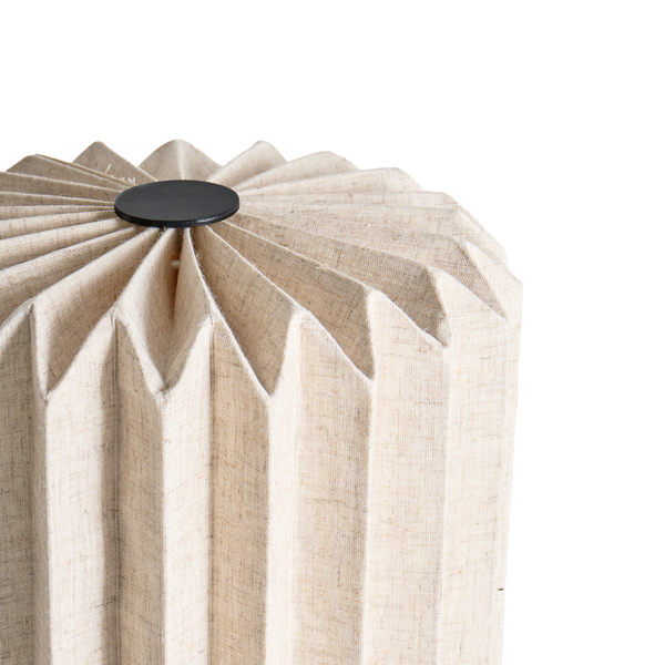 Detailansicht eines plissierten Lampenschirms aus strukturiertem Stoff mit schwarzer Abdeckung oben.