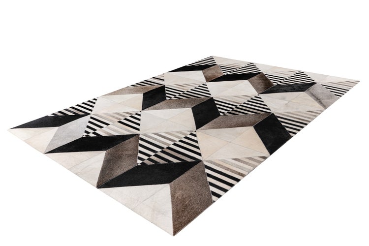 Rechteckiger Teppich aus Kuhfell mit geometrischem Patchwork-Muster aus Dreiecken und Streifen.
