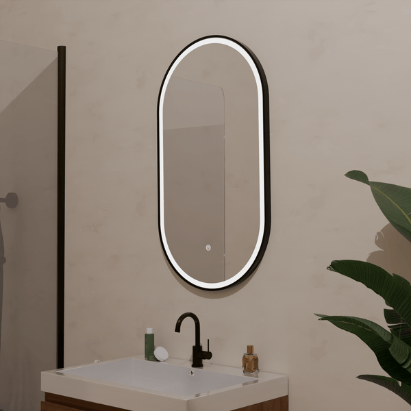 Ovaler Badezimmerspiegel mit LED Beleuchtung und schwarzem Rahmen über einem Waschbecken mit Armatur in einem modern gestalteten Badezimmer