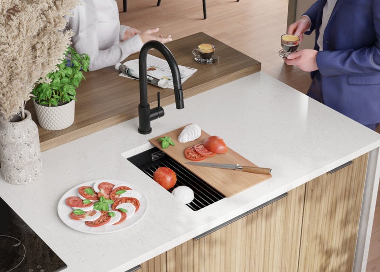 Küchenszene mit Spüle, Armatur, Schneidebrett und Zutaten für Caprese-Salat.