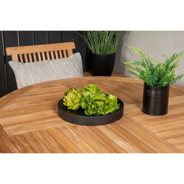 Gartenszene mit Holztisch, Stuhl, Kissen, Dekoration und Pflanzen