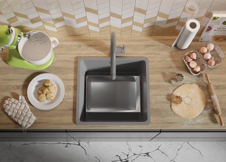 Küchenszene mit Spüle, Armatur, Rührgerät, Backzutaten und fertigen Keksen auf einer Arbeitsplatte.