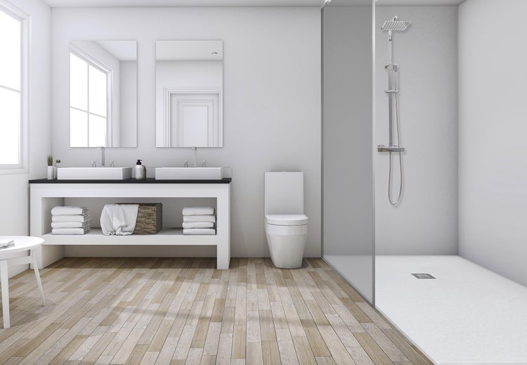Modernes Badezimmer mit Doppelwaschtisch, Toilette und bodengleicher Dusche in einem hellen und geräumigen Interieur mit Holzoptik Bodenbelag.