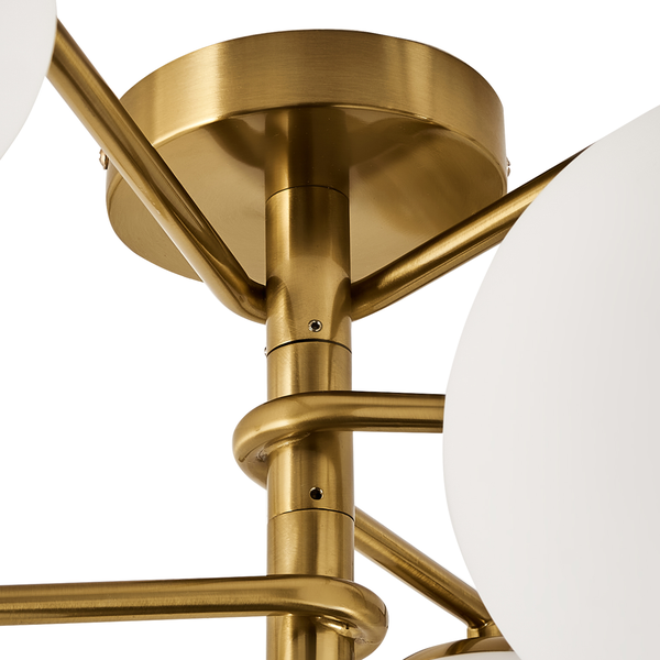 Detailansicht einer Deckenleuchte mit goldenem Gestell und kugelförmigen Lampenschirmen.