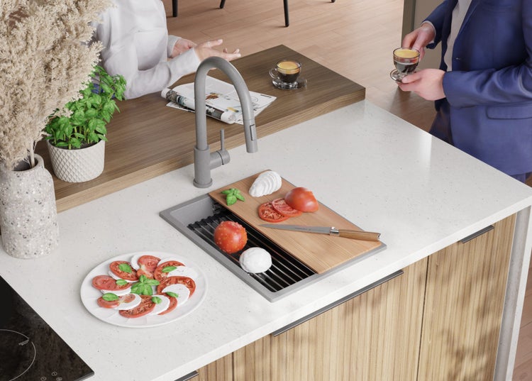 Küchenspüle mit Armatur, Schneidebrett, Lebensmitteln und Geschirr auf einer modernen Küchentheke