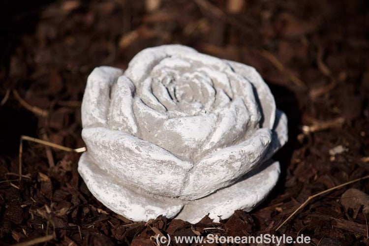 Dekorative Rosenblüte aus Beton als Gartenfigur zur Dekoration von Beeten.