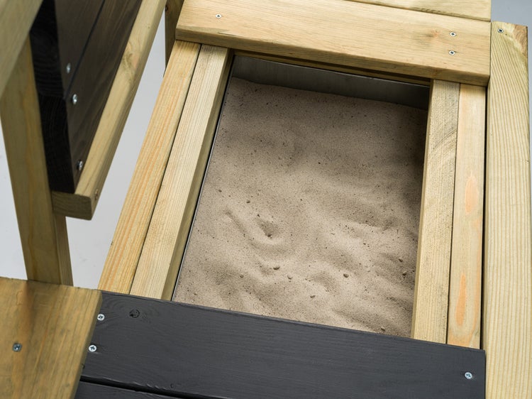 Detailansicht eines Sandkastens aus Holz mit Sandfüllung