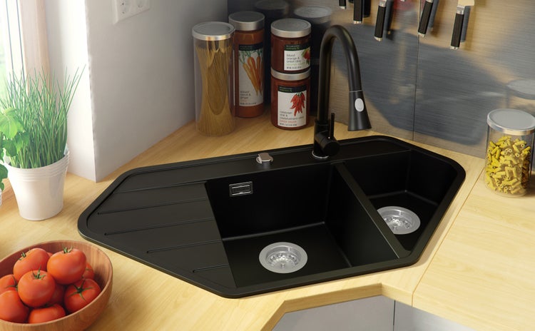 Eckspüle mit Abtropffläche und Wasserhahn in einer hellen Küche.