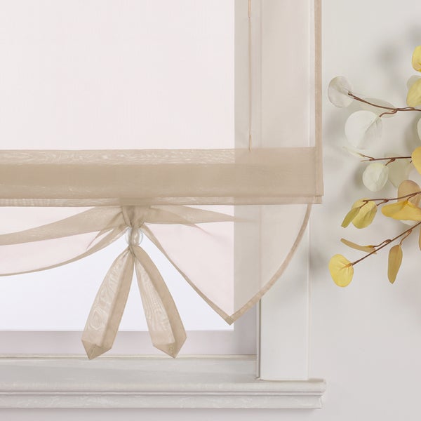 Dekoratives Faltrollo am Fenster mit floralem Akzent.