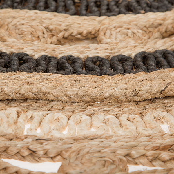 Nahaufnahme eines gewebten Teppichs aus Jute mit geflochtenen Seilen in Naturfarben und Schwarz.