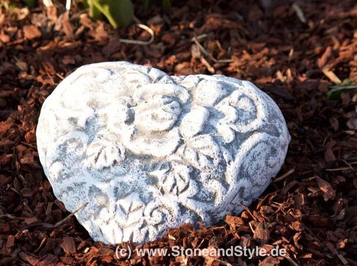 Herzförmiges Dekorationselement aus Stein mit floralen Verzierungen zur Gartenverschönerung