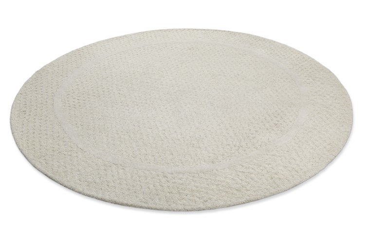 Runder Teppich mit strukturierter Oberfläche und dezentem kreisförmigem Randdesign.