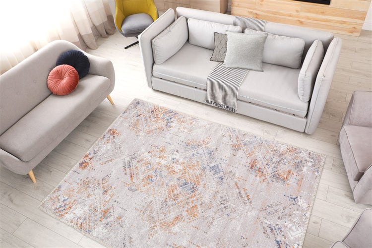 Rechteckiger Wohnzimmerteppich mit orientalischem Vintage-Muster in hellem Wohnzimmer mit grauen Sofas und hellem Holzboden.