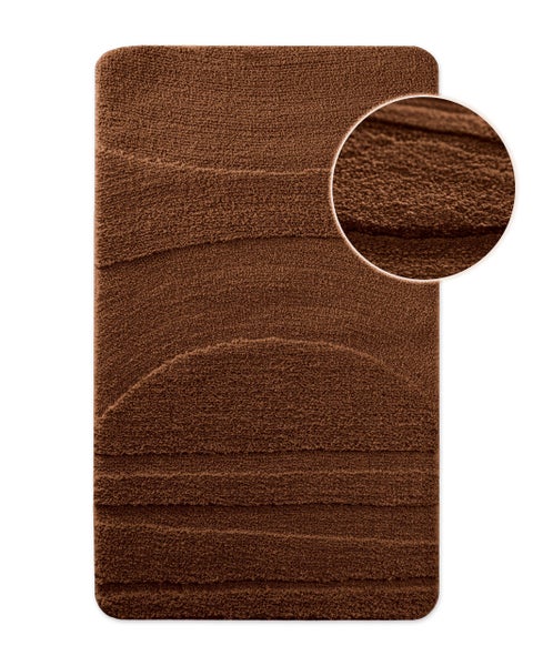 Rechteckiger brauner Badeteppich mit abgerundeten Ecken und wellenförmigem Hochflor-Muster sowie Nahaufnahme der Textur.