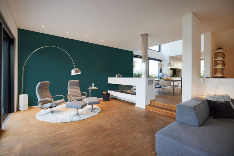 Helles Wohnzimmer mit Sesseln, Kamin und Holzboden