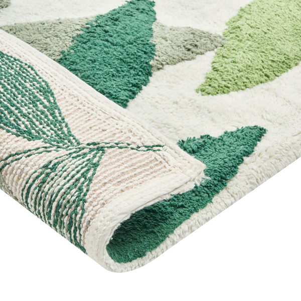 Teppich mit geometrischem Muster in verschiedenen Grüntönen und Weiß, teilweise aufgerollt