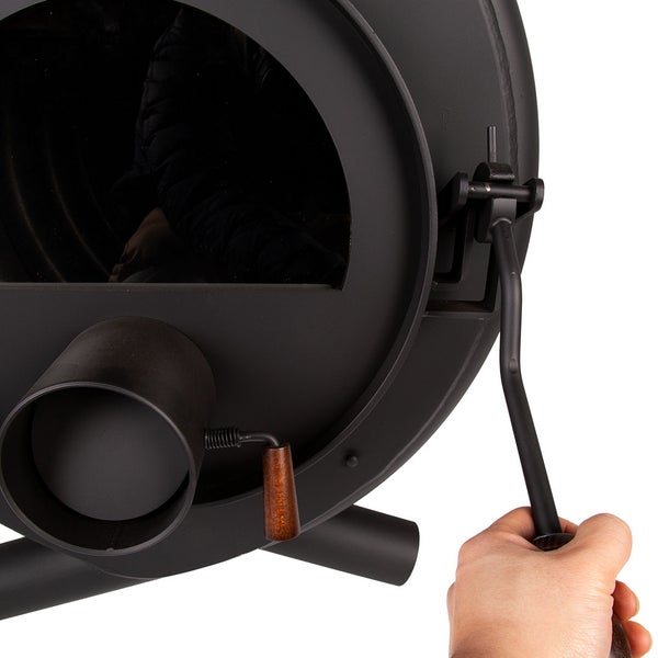 Detailansicht eines Ofens mit Hand, das den Griff betätigt.